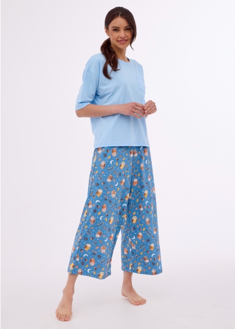Dwuczęściowa piżama damska. Bluzka piżamowa w kolorze niebieskim ma klasyczny luźny krój pudełkowy. Rękawy 3/4 dodają elegancji i subtelności. Spodnie piżamowe ozdobione delikatnym, stylizowanym drukiem sów, nadają jej wyjątkowego uroku i charakteru.