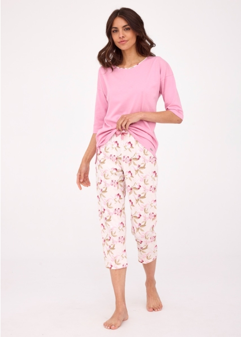 Kobieca piżama damska składająca się z różowej bluzki o długości rękawów 3/4 i dekolcie wykończonym okrągłą lamówką. Bluzka jest wykonana z miękkiej, przyjemnej w dotyku bawełny, która zapewnia komfort noszenia. Spodnie o długości 7/8 są zadrukowane piękn