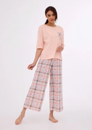 Wyjątkowa piżama damska z bluzką kroju pudełkowego w kolorze jasnego różu. Rękawy 3/4 . Spodnie w klasyczną kratę mają szeroki krój i długość 7/8, co zapewnia swobodę ruchów i komfort noszenia. 